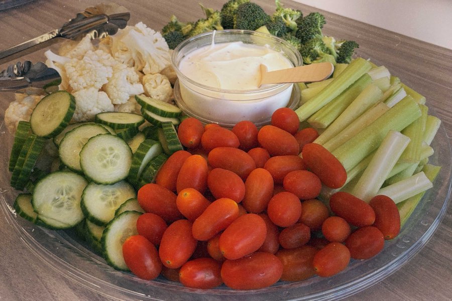 Fresh vegetable tray with broccoli, cauliflower, cucumber, celery and cherry tomatoes with ranch dip