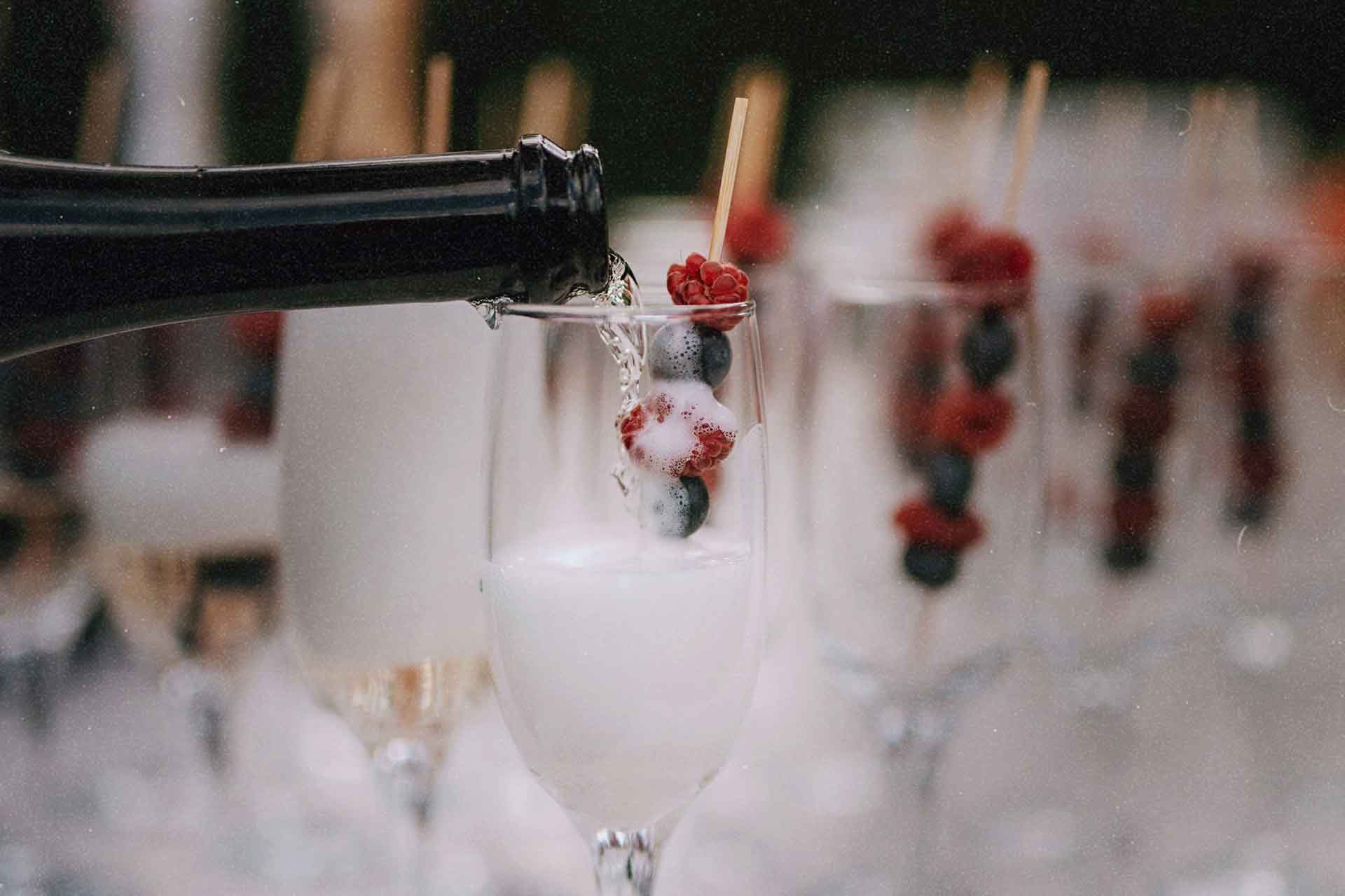 A professional bartender pouring garnished champagne for a luxury event in the Halifax area.